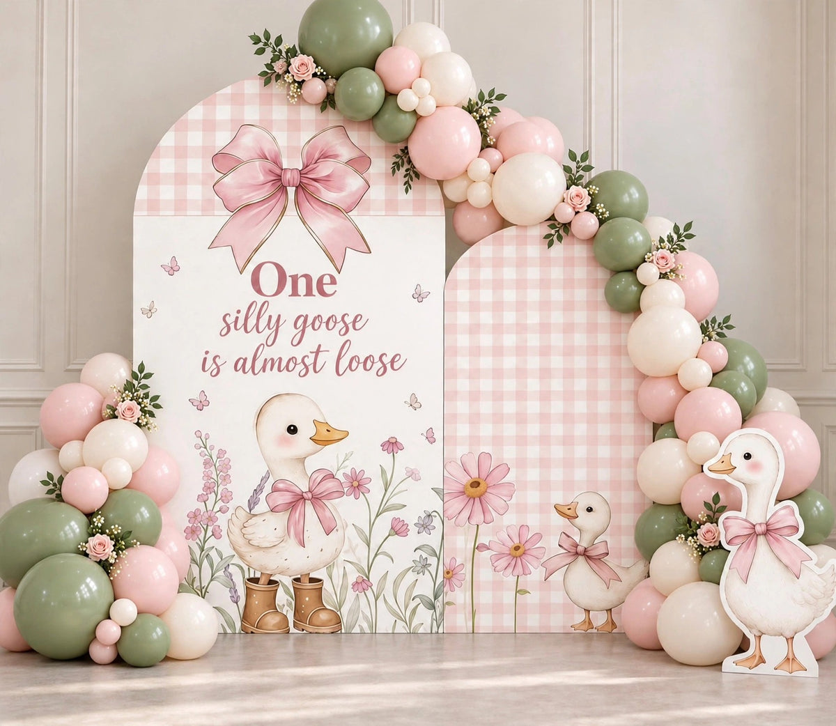 One silly goose sage green first birthday balloon backdrop with goose in boots
