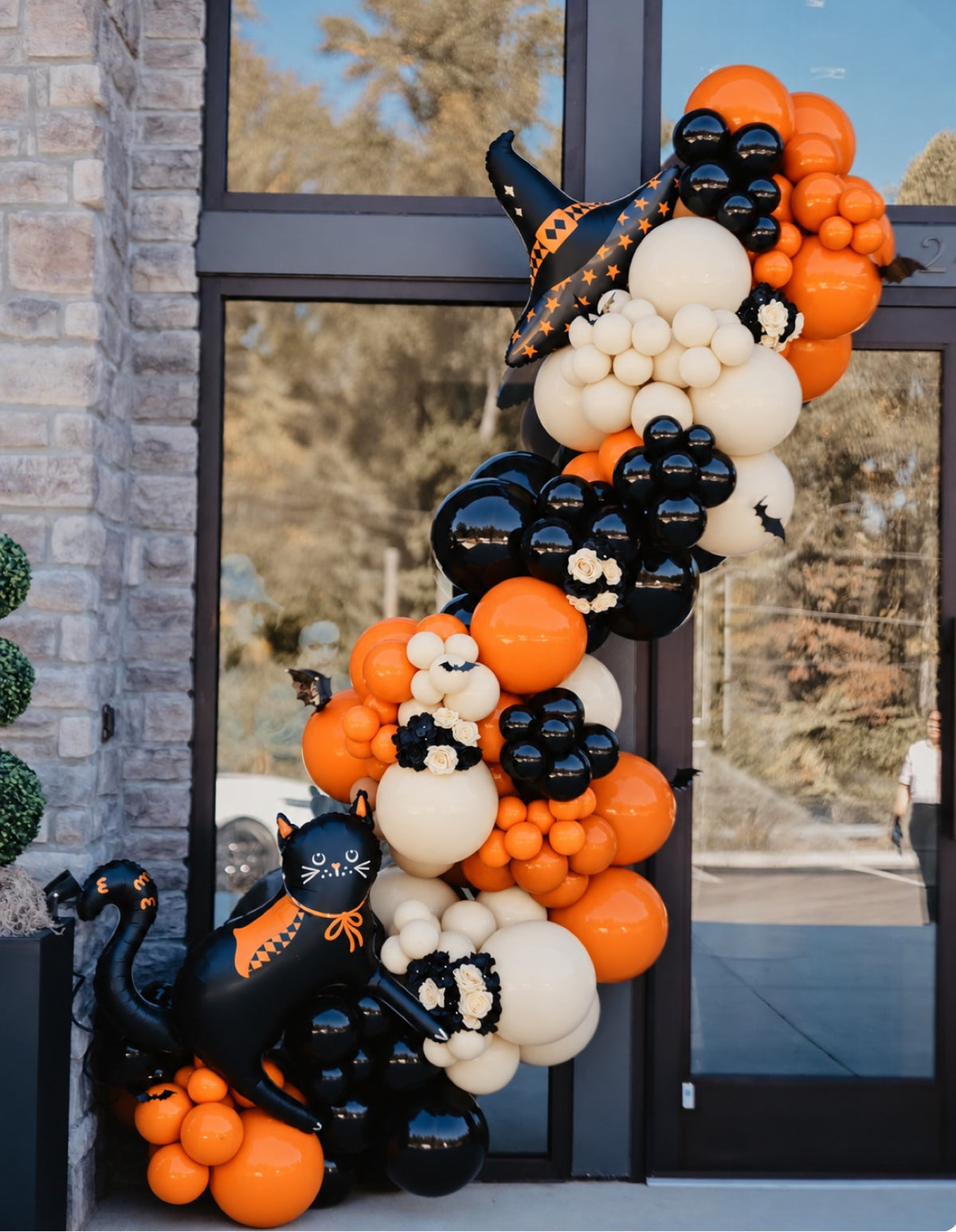 Halloween balloon garland with black cat and witch hat foil balloons in orange black and ivory