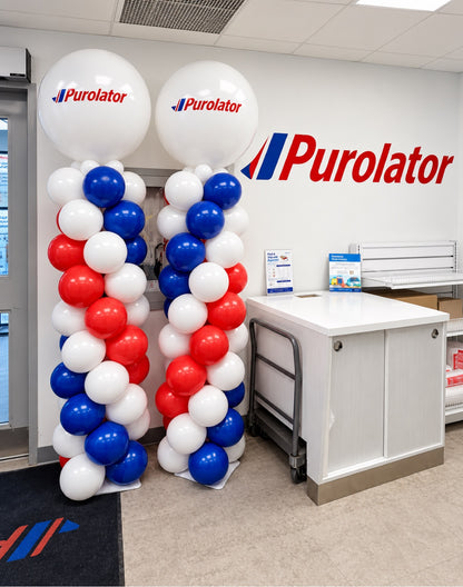 Two classic spiral balloon columns / pillars in red, white and blue with Purolator logo toppers at a Purolator office
