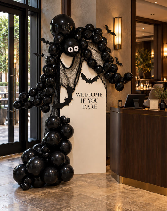 Elegant black Halloween balloon garland on welcome if you dare backdrop with bats