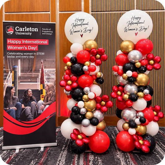 Two organic balloon columns / pillars in red, black, gold and white with Happy International Women's Day toppers at a Carleton University event