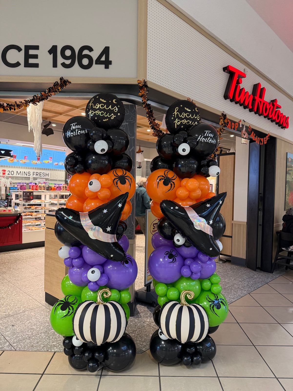 Halloween balloon columns in black, orange, purple and green with witch hats, pumpkins and Hocus Pocus balloons