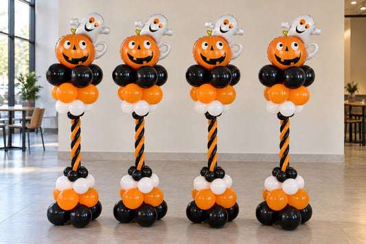 Halloween spiral balloon columns with pumpkin and ghost foil toppers in orange black and white