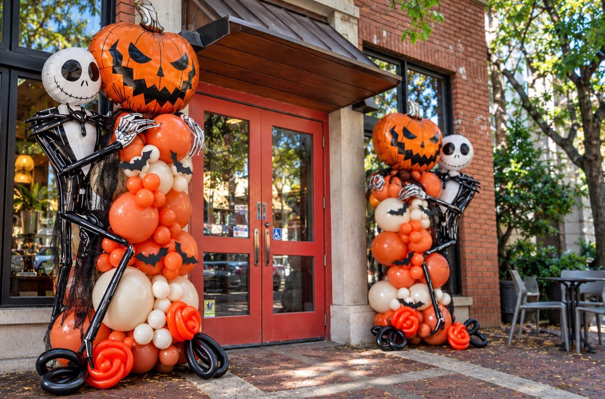 Close-up of Halloween balloon columns with pumpkin and skeleton foil balloons at cafe entrance