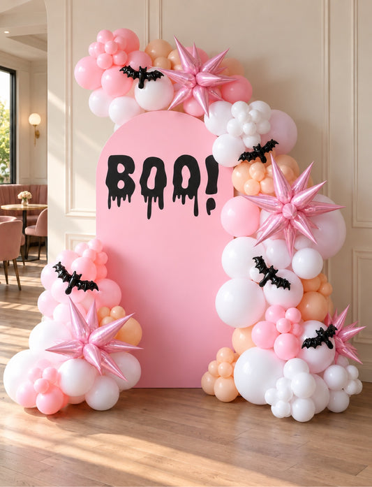 Pink Halloween BOO backdrop with pink white and peach balloon garland and bat decorations