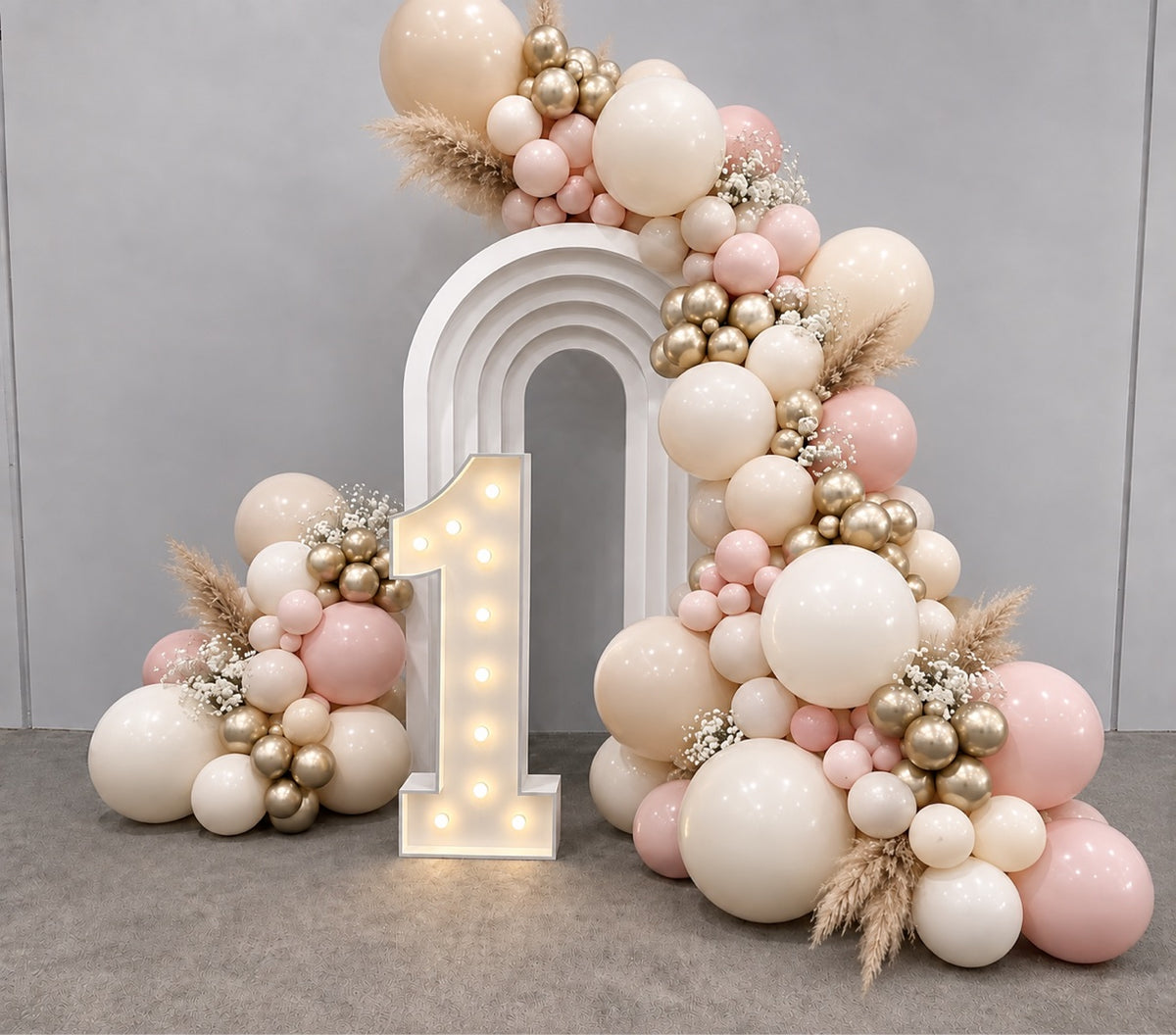 White rainbow first birthday balloon backdrop with light-up number one