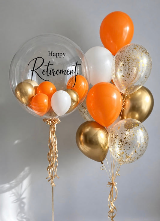 Happy Retirement balloon bouquet in orange, gold and white with a large clear Happy Retirement balloon